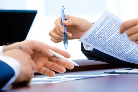 Hand signing an account agreement on a desk